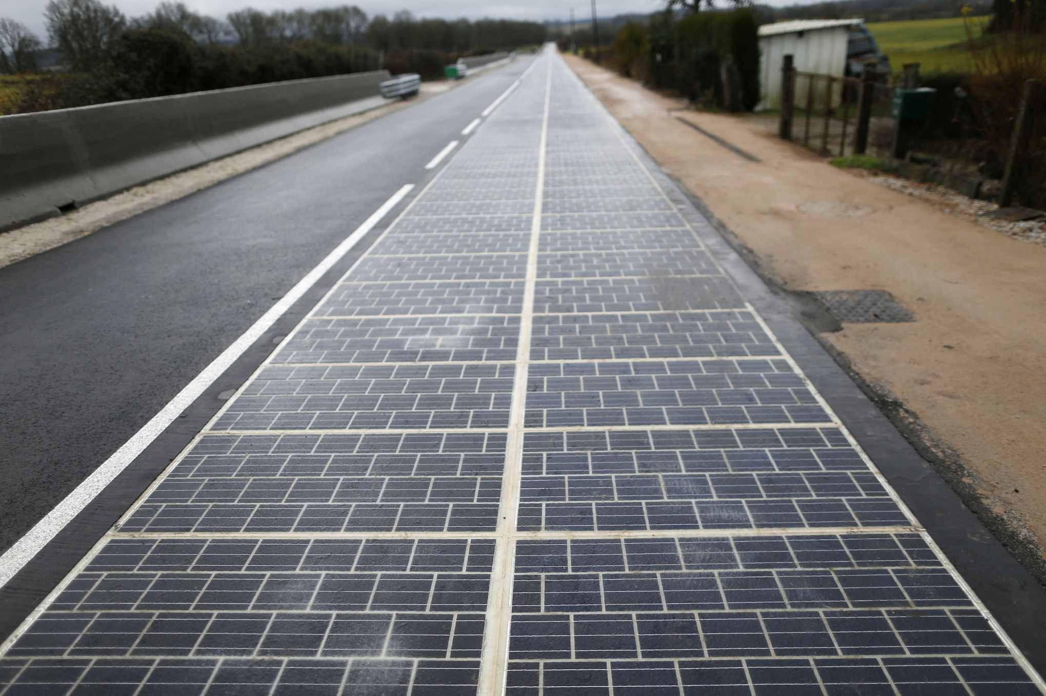 A solar panel road is pictured on December 22, 2016, following its inauguration in Tourouvre, Normandy, northwestern France. The world's first solar road was inaugurated on Thursday in Normandy, a technology the minister hopes will develop in France and abroad despite criticism of its high cost and profitability. / AFP PHOTO / CHARLY TRIBALLEAU